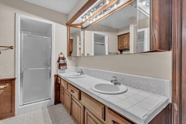 bathroom featuring tile patterned flooring, vanity, and a shower with door