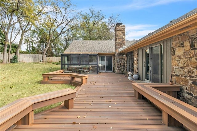 wooden deck featuring a sunroom and a yard