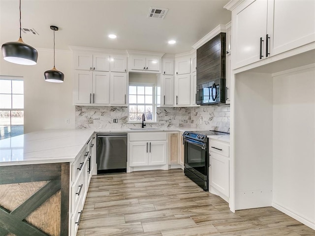 kitchen with white cabinets, sink, stainless steel dishwasher, black / electric stove, and decorative light fixtures