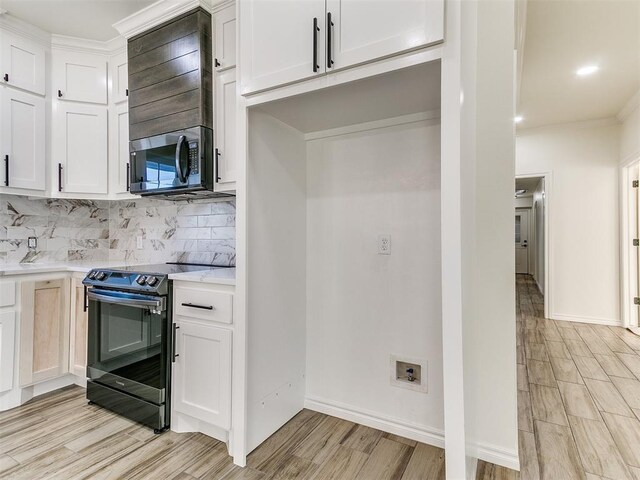 kitchen with backsplash, white cabinets, light hardwood / wood-style floors, and black range with electric cooktop