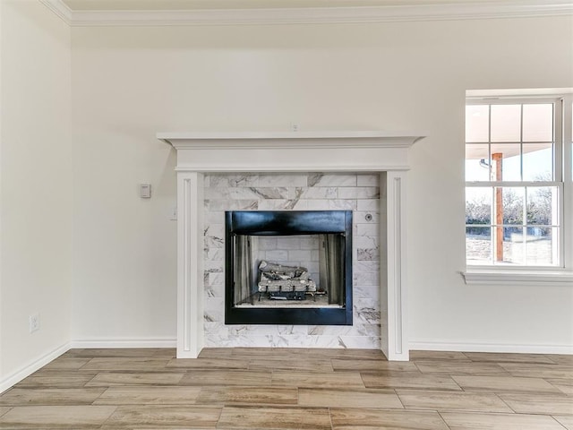 interior details with a tile fireplace and ornamental molding