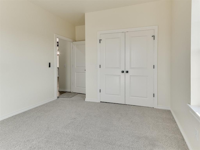 unfurnished bedroom with light carpet and a closet