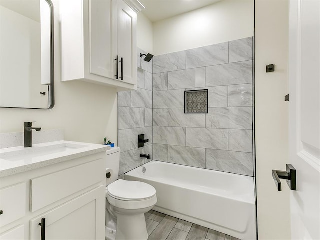 full bathroom with vanity, toilet, and tiled shower / bath