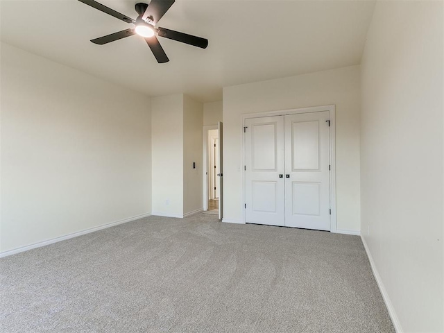 unfurnished bedroom with ceiling fan, light carpet, and a closet