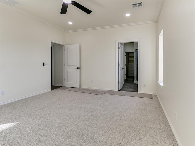 unfurnished room featuring carpet floors, ceiling fan, and crown molding