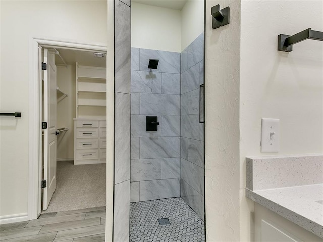 bathroom featuring vanity and tiled shower