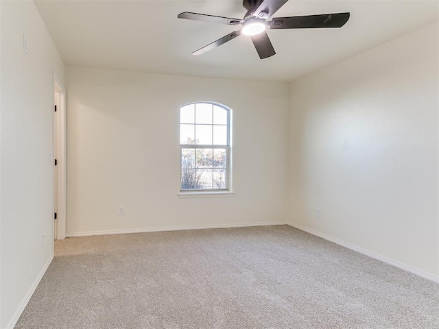 spare room with ceiling fan and light colored carpet