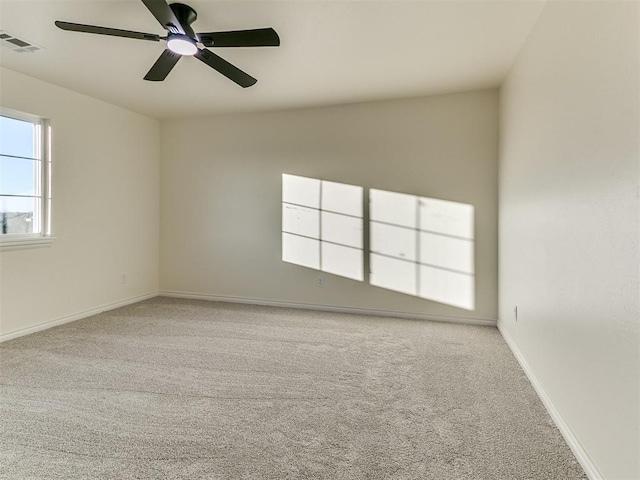 carpeted spare room featuring ceiling fan