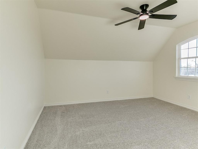 additional living space featuring light colored carpet, vaulted ceiling, and ceiling fan