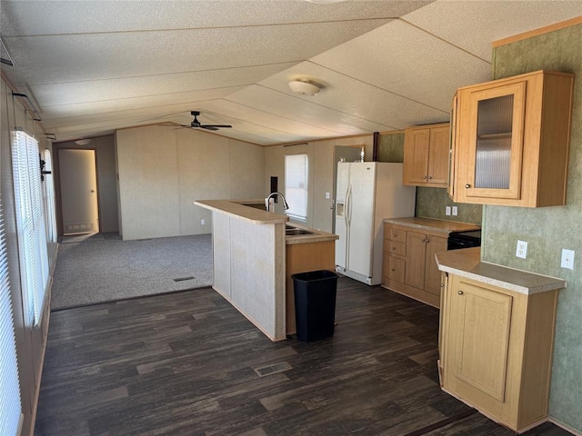 kitchen featuring dark hardwood / wood-style flooring, vaulted ceiling, ceiling fan, sink, and white refrigerator with ice dispenser