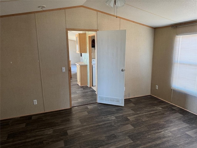 spare room featuring a textured ceiling, dark hardwood / wood-style flooring, ceiling fan, and lofted ceiling