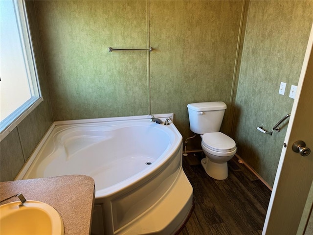 bathroom with wood-type flooring, toilet, and a bathtub