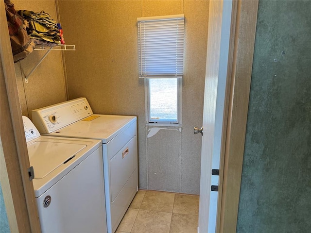 laundry area with washing machine and clothes dryer and light tile patterned floors