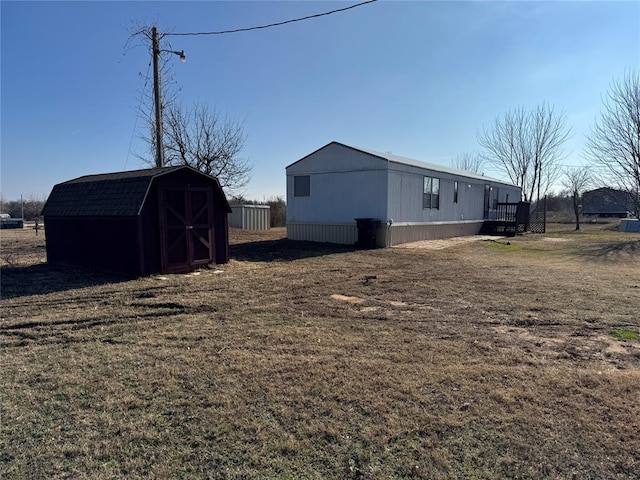 view of side of property with a lawn and a storage unit