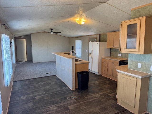 kitchen featuring lofted ceiling, a healthy amount of sunlight, white refrigerator with ice dispenser, and sink