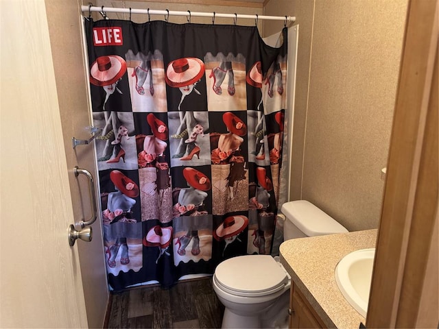 bathroom featuring hardwood / wood-style flooring, vanity, a shower with shower curtain, and toilet