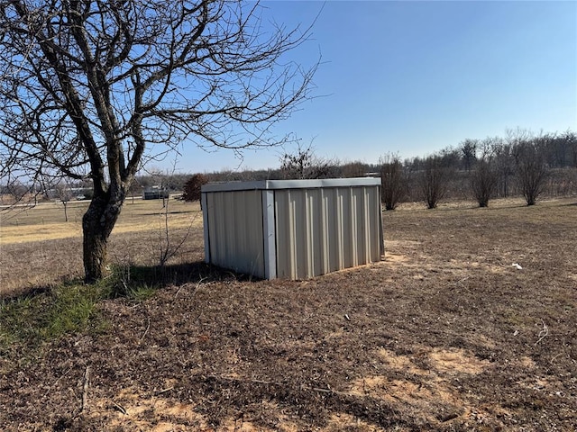 view of yard with a shed and a rural view