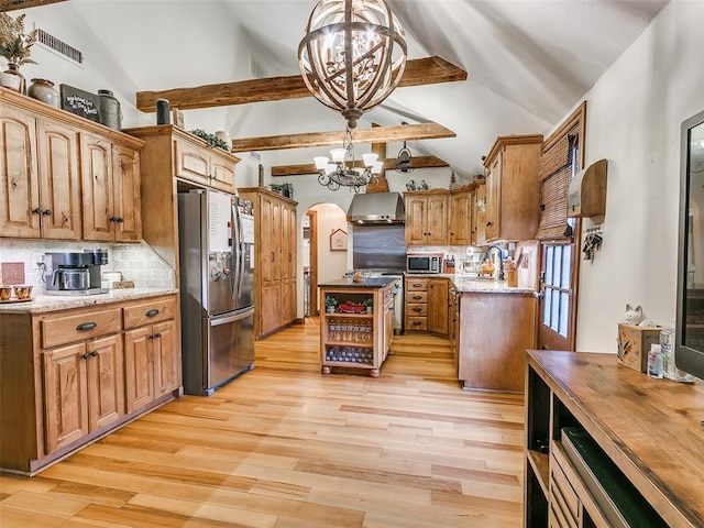 kitchen featuring appliances with stainless steel finishes, tasteful backsplash, wall chimney exhaust hood, decorative light fixtures, and a chandelier