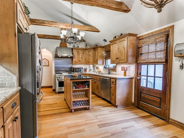 kitchen with a center island, an inviting chandelier, sink, wall chimney exhaust hood, and appliances with stainless steel finishes