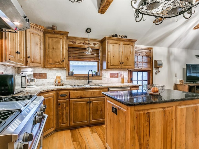 kitchen with a center island, sink, stainless steel appliances, light hardwood / wood-style flooring, and beamed ceiling