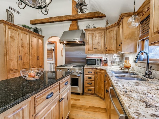 kitchen with sink, range hood, light hardwood / wood-style floors, light stone counters, and stainless steel appliances