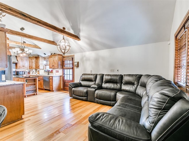 living room with light wood-type flooring, a healthy amount of sunlight, sink, lofted ceiling with beams, and a notable chandelier