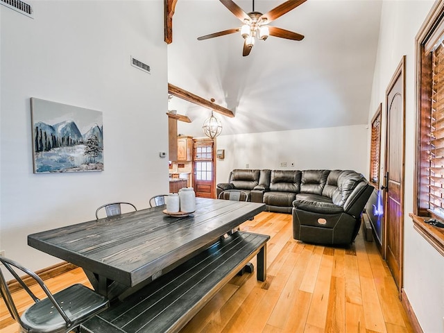 living room with ceiling fan with notable chandelier, hardwood / wood-style flooring, and vaulted ceiling