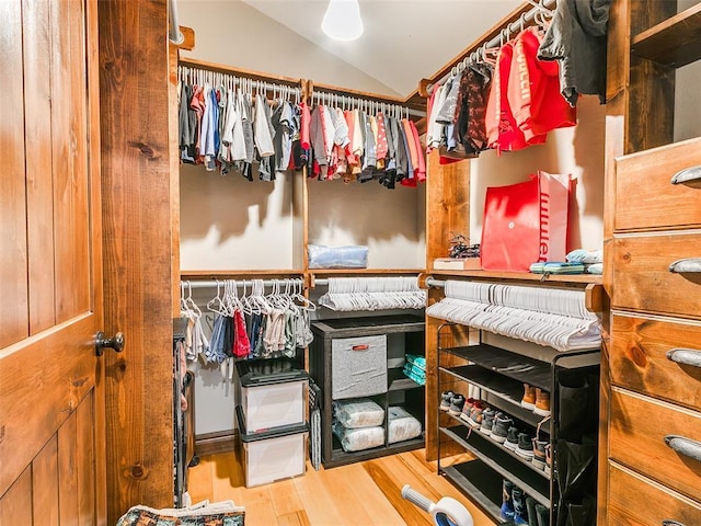 walk in closet featuring hardwood / wood-style floors and vaulted ceiling