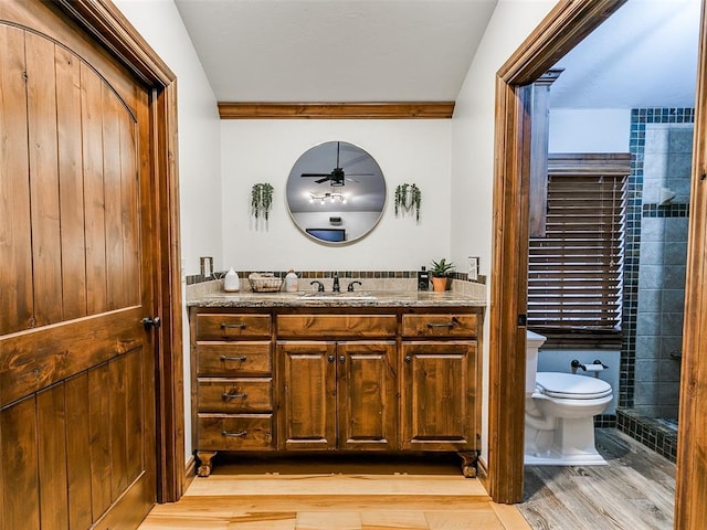 bathroom featuring ceiling fan, crown molding, wood-type flooring, toilet, and vanity