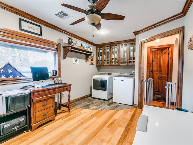 washroom featuring light hardwood / wood-style floors, cabinets, separate washer and dryer, and ornamental molding