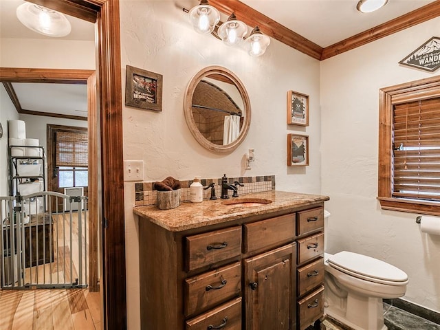 bathroom featuring vanity, ornamental molding, and toilet