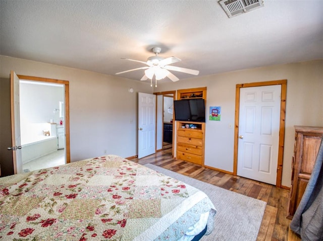 bedroom with hardwood / wood-style flooring, ceiling fan, and connected bathroom