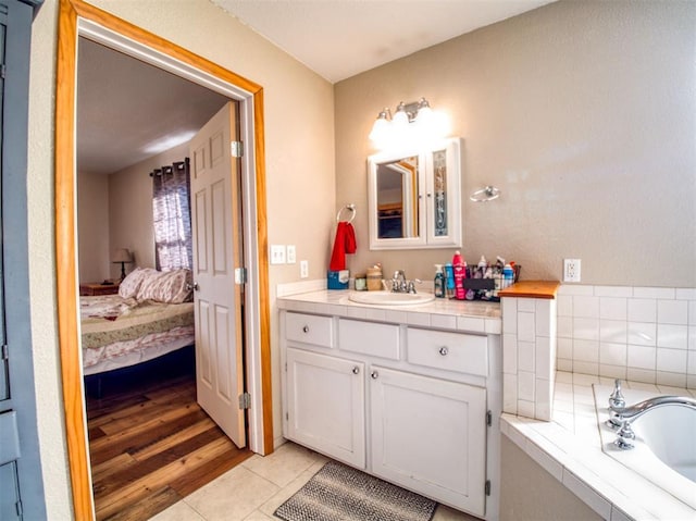 bathroom with a tub to relax in, tile patterned flooring, and vanity