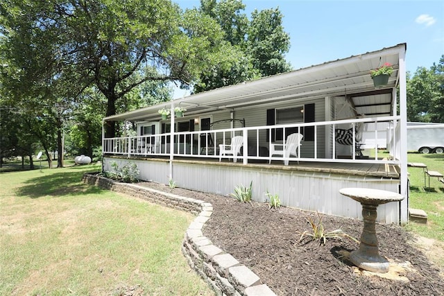 back of house featuring a lawn and covered porch