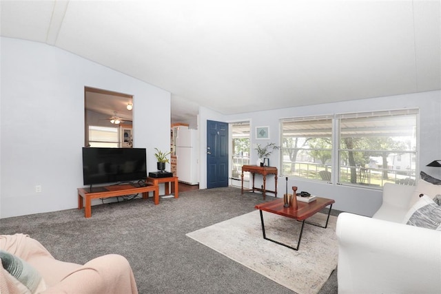 carpeted living room with ceiling fan and vaulted ceiling