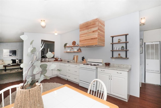 kitchen with white gas range, white cabinets, dark hardwood / wood-style floors, and custom exhaust hood