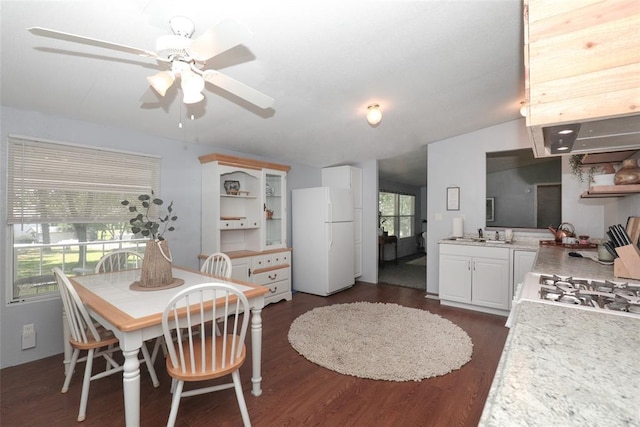 dining area with ceiling fan, sink, and dark wood-type flooring