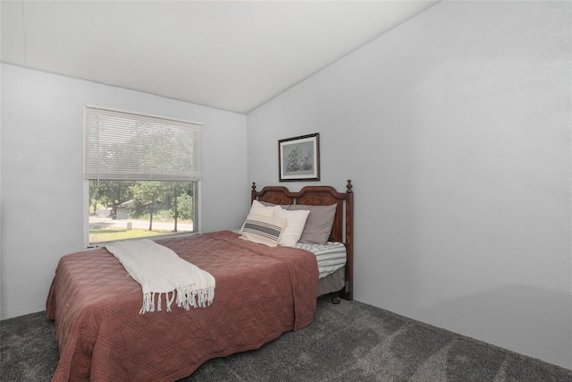 bedroom with dark carpet and lofted ceiling