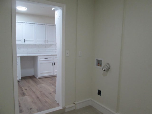 laundry room featuring laundry area, baseboards, washer hookup, and light wood finished floors