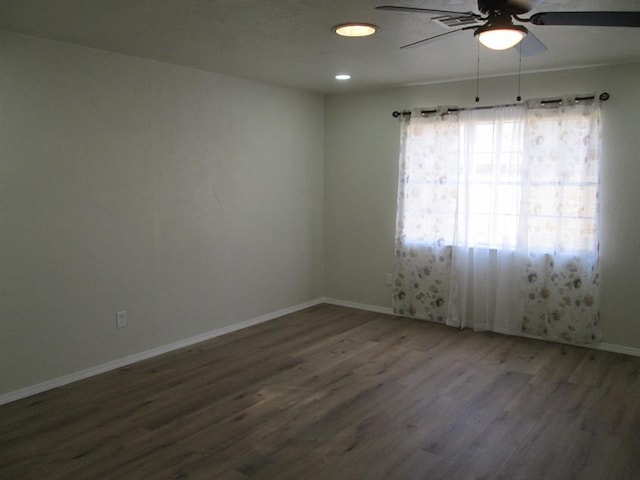 unfurnished room featuring a ceiling fan, baseboards, and wood finished floors