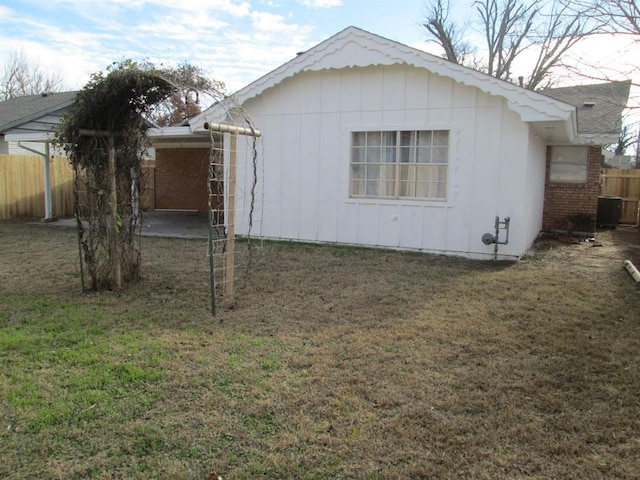 view of home's exterior featuring central AC, a yard, and fence