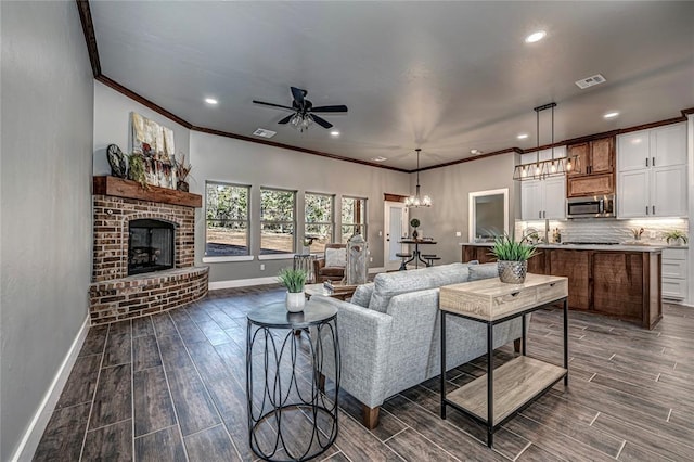 living room featuring a fireplace and ceiling fan with notable chandelier