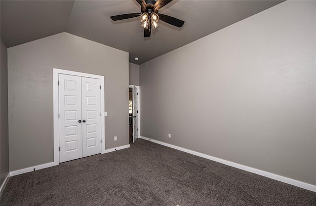 unfurnished bedroom featuring ceiling fan, a closet, dark carpet, and vaulted ceiling