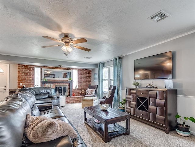 carpeted living room with ceiling fan, a textured ceiling, and a brick fireplace