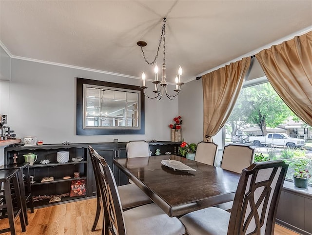 dining area featuring a chandelier, light hardwood / wood-style floors, and crown molding