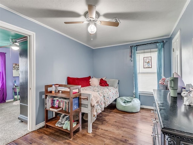 bedroom featuring ceiling fan, crown molding, a textured ceiling, and hardwood / wood-style flooring