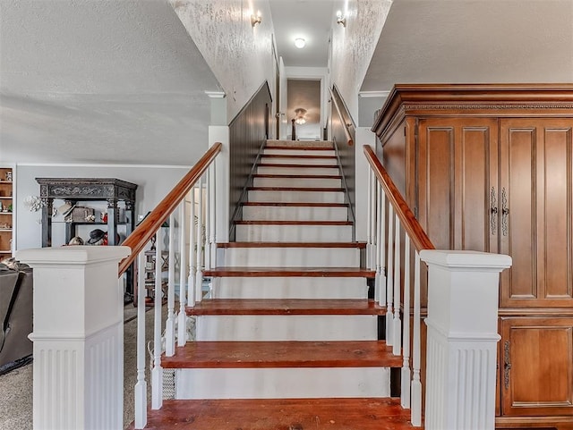 stairs featuring a textured ceiling