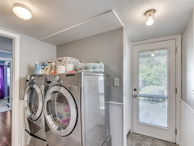 clothes washing area featuring washer and dryer and a textured ceiling