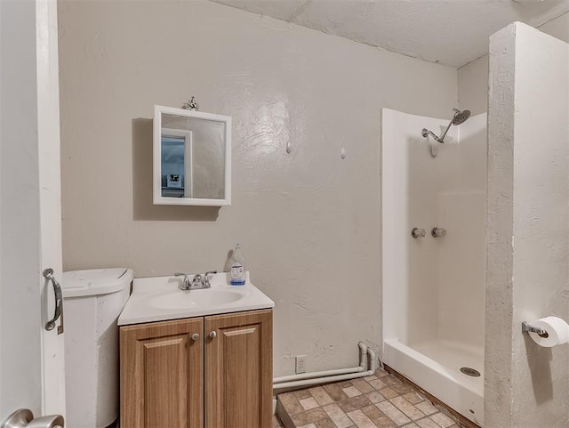 bathroom featuring vanity, toilet, and walk in shower