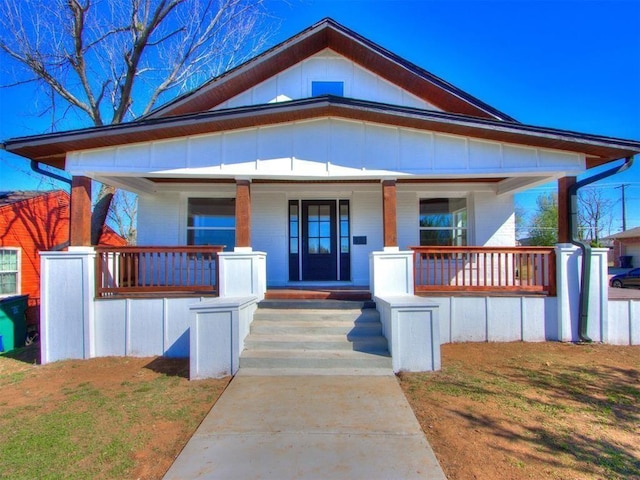 bungalow with covered porch and a front yard